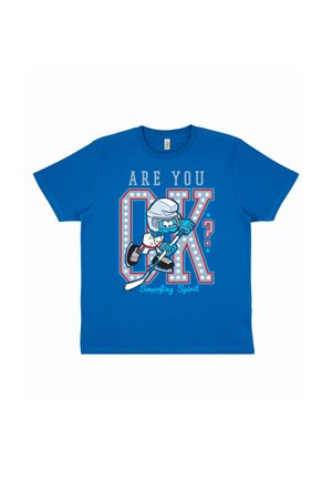 T-shirt bleu avec un joueur de hockey en dessin animé portant un casque et des patins, texte « Ça va ? » et « Esprit Schtroumpf » sous de grandes lettres décorées OK.