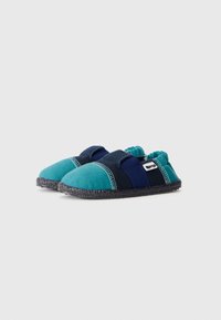 Ett par blå och teal tofflor för småbarn med svarta texturerade sulor och elastisk baksida för lätt påtagning.