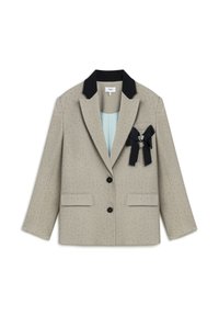 Beige blazer met zwarte kraag, twee voorkoeken en een decoratieve broche. Heeft een subtiele pin-dot textuur en sluit met een enkele knop.
