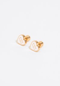 Gold-tone heart-shaped earrings with white enamel featuring "Bimba Y Lola" text. Smooth texture, polished finish, compact design.