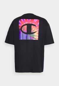Černé tričko s krátkým rukávem, které má na přední straně square ve stylu tie-dye s výrazným logem uprostřed. Měkká tkanina, volný střih.