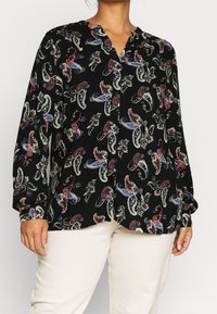 Black blouse with a paisley pattern in red, white, and blue. Features a V-neck and long sleeves with buttoned cuffs. Made from lightweight fabric.