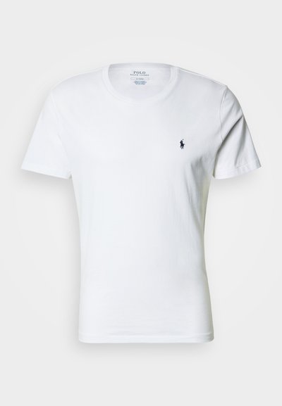 Fehér pamut póló kerek nyakkivágással, rövid ujjakkal és egy kis tengerészkék logóval a bal mellrészen. Simaságú anyag és normál szabás.