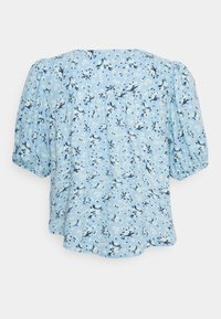 Blusa azul-clara com padrão floral em branco e azul-escuro. Mangas ballon, corte descontraído e detalhes franzidos na parte de trás.
