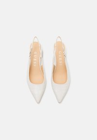Tacchi slingback bianchi a punta con texture coccodrillo, dotati di una soletta color beige chiaro e di una sottile cinghia alla caviglia con hardware argentato.