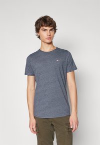 Kortärmad marinblå t-shirt i ett mjukt, strukturerat tyg med rundad halsringning och en liten logotyp på bröstet.