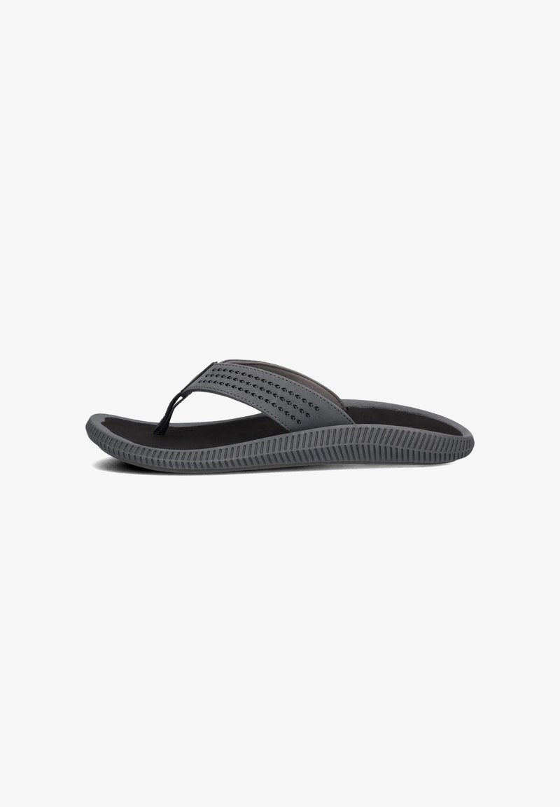 Grijze teenslipper met een gestructureerde zwarte zool, een dunne band met perforaties en een flexibele rubberen constructie voor comfort en draaggemak.