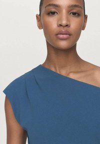 Blaues, einseitiges Kleid mit weicher Textur, das eine plissierte Detail am Schulterbereich aufweist. Einfaches, modernes Design mit klarer Silhouette.