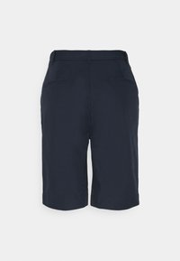 Pantalones cortos de sastre azul marino oscuro con trabillas para cinturón, dos bolsillos de ojal traseros y un dobladillo hasta la rodilla, exhibidos sobre un fondo claro.