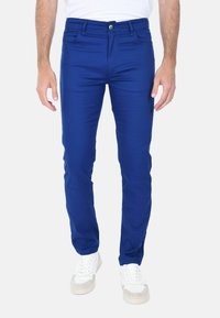 Pantaloni aderenti di colore blu brillante realizzati in tessuto leggero, con un classico design a cinque tasche e chiusura anteriore con bottone.