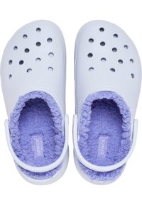 Sabots en caoutchouc blancs avec des trous de ventilation, dotés d'une doublure en fourrure lavande douce et d'une sangle au talon réglable.