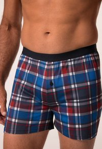 Pánské boxerky v kostkovaném vzoru se modrými, červenými a šedými čtverci. Elastický černý pás s detailem středového knoflíku. Měkká bavlněná tkanina.