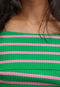 Haut côtelé rayé vert et rose avec un décolleté carré et un tissu texturé, présentant des rayures horizontales de largeurs variées.