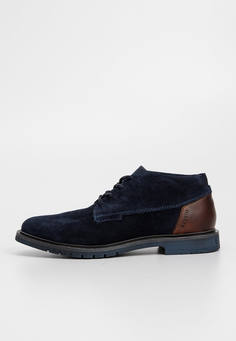 Navy Wildleder Chukka-Stiefel mit einem braunen Lederabsatz, kontrastierenden Nähten und einer strukturierten Gummisohle für Grip.