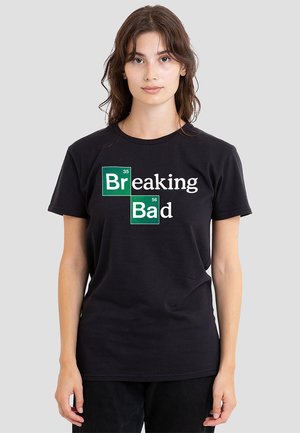 Black cotton t-shirt featuring a graphic design with "Breaking" in white and "Bad" in white, enclosed in green elements with atomic numbers.