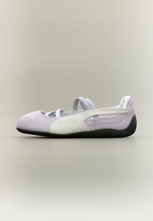 Light purple suede ballet flat shoe with white Puma stripe, elastic straps, and black rubber sole on neutral background.