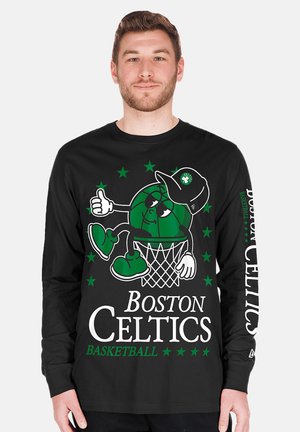 Mann trägt ein schwarzes Boston Celtics Langarmshirt mit einem Cartoon-Basketballcharakter, der im Korb ein Daumen-hoch-Zeichen zeigt.