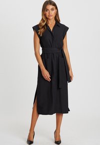 Musta vyöllinen midi-mekko lyhyillä hihoilla, etupainikkeilla, sivuhaalareilla ja kahdella taskulla, valmistettu kevyestä kankaasta, jolla on sileä rakenne.
