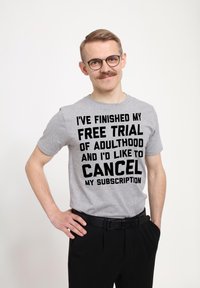 Grå t-shirt i bomull med fet svart text: "JAG HAR AVSLUTAT MIN GRATISPRÖVNING AV VUXENDOM OCH JAG VILL AVBESTÄLLA MIN PRONUMERATION."