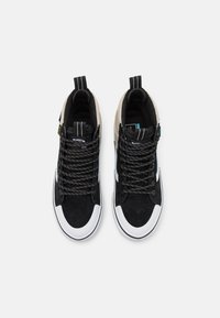 Sorte semsket høye sneakers med hvite gummisåler, grå detaljer, svarte mønstrede snørebånd og håndtak på hælene.