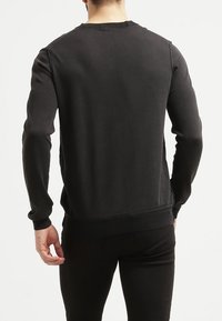 Czarna bawełniana bluza z długim rękawem, z prążkowanymi mankietami i dołem, z klasycznym okrągłym dekoltem i minimalistycznym wzornictwem.
