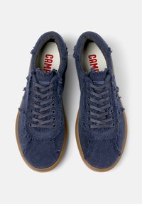 Marina blåa sneakers i avslappnad stil med fransad tyg, rund tå och grå snören. Har en strukturerad kanvasöverdel och en ljusbrun gummisula.