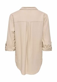 Chemise beige à manches longues avec poignets retroussés, empiècement dos et pli creux central, présentée sur fond blanc.