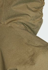 Waterproof olive green fabric with a slightly shiny texture, featuring small water droplet patterns and gathered detailing.