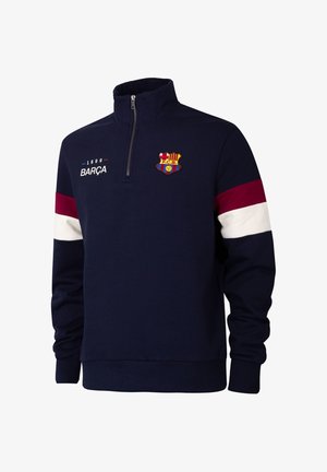 Marineblauwe sweater met een kwart-ritssluiting, rode en witte strepen op de mouwen, FC Barcelona-logo en tekst "1899 BARÇA" op de borst.