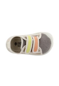 Zapato textil de color beige con punta gris, que cuenta con dos tiras de velcro en verde claro y naranja. Suela blanda y diseño transpirable.