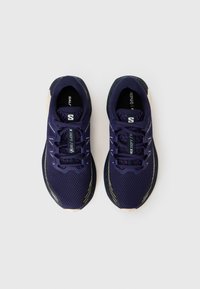 Paarse sportschoenen met een mesh bovenwerk, een ronde neus, een dikke zool en contrasterende crèmekleurige accenten. Voorzien van veters en logo-details.