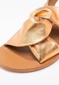 KIOMI Sandaalit nilkkaremmillä - bronze