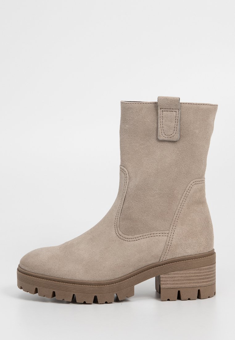 Beżowe zamszowe botki do połowy łydki z masywną podeszwą, szerokim obcasem i pętlą do ściągania na górnej części cholewki.
