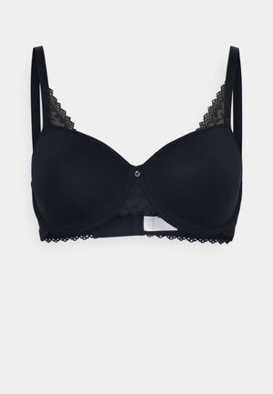 Reggiseno nero con coppe imbottite lisce, pizzo lungo le bretelle e le coppe, e un piccolo dettaglio decorativo al centro anteriore. Bretelle regolabili.