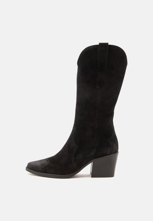 Botte mi-mollet en daim noir avec bout pointu, talon bloc et languette en haut sur fond blanc uni.