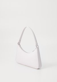 Vaaleanpunainen nahkainen olkalaukku, jossa pyöristetty yläosa ja yksi olkahihna. Hopeanväriset metalliosat hihnan lähellä, sileä pinta ja minimalistinen muotoilu.