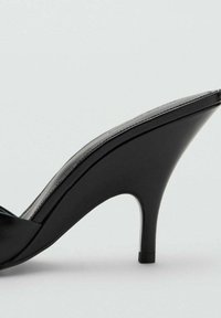 Scarpa nera con tacco alto, con punta affusolata, in pelle lucida e design elegante e curvo. Il tacco stiletto aggiunge altezza ed eleganza.