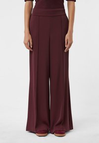 Weite Hosen aus burgunderfarbenem Stoff mit glatter Textur, ausgestattet mit einem hohen Bund und Vorderfalten für einen maßgeschneiderten Look.