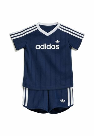 Tenue bébé Adidas bleu marine avec des bandes blanches sur les épaules et les shorts, avec le logo Adidas sur le t-shirt et les shorts.
