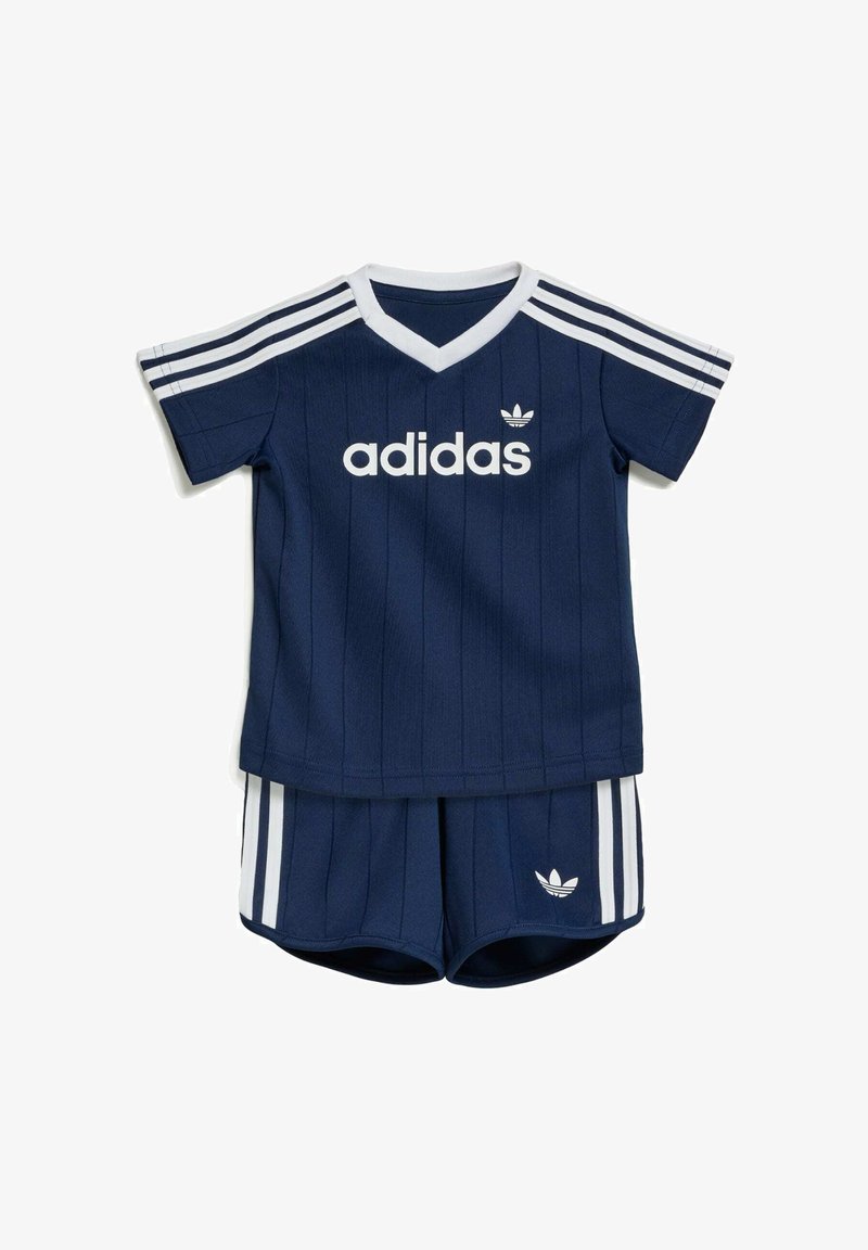 Tenue bébé Adidas bleu marine avec des bandes blanches sur les épaules et les shorts, avec le logo Adidas sur le t-shirt et les shorts.