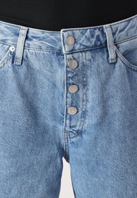 Light blue denim high-waisted jeans with a straight cut. Features five metallic buttons with a logo at the front and belt loops at the waist.