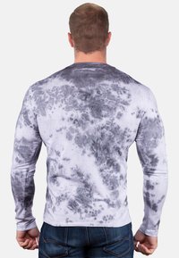 Langarmshirt mit einem Batikmuster in Weiß- und Grautönen, aus weichem Stoff gefertigt, mit klassischem Rundhalsausschnitt und taillierter Passform.