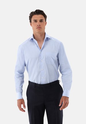 Light blue striped dress shirt with a button-down collar and single chest pocket, paired with dark trousers. Smooth fabric texture.