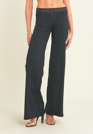 Mustat leveälahkeiset housut, joissa on sileä pinta, istuva vyötärönauha, kaksoispainikkeet ja kontrastisaumat.