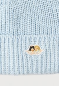 Ανοιχτό μπλε πλεκτό σκουφάκι με ραβδωτή υφή που έχει κεντημένο σχέδιο σύννεφου με δύο φιγούρες σε απαλά χρώματα.