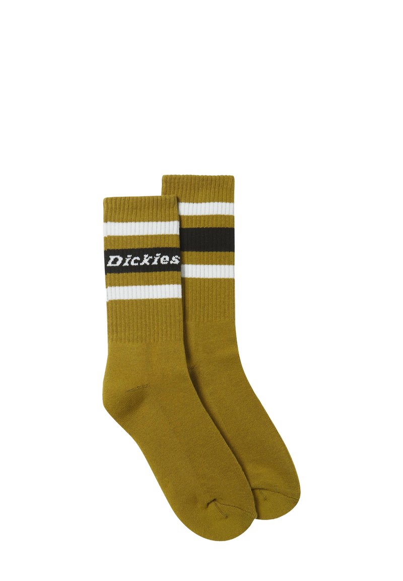 Kaks mustard-keltaista crewsukkia, joissa on valkoisia ja mustia raitoja ylhäällä, toinen sukka esittelee "Dickies"-merkin nimen valkoisella tekstillä.