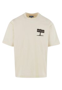 Creme bomulds t-shirt med korte ærmer, med et sort "FORSIGTIG" skilt grafik på venstre brystområde. Glat tekstur.