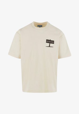 Creme bomulds t-shirt med korte ærmer, med et sort "FORSIGTIG" skilt grafik på venstre brystområde. Glat tekstur.