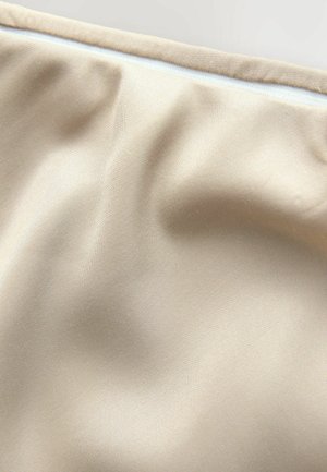 Beige stof met een gladde textuur, voorzien van subtiele plooien en een contrasterende witte rits langs de bovenrand.