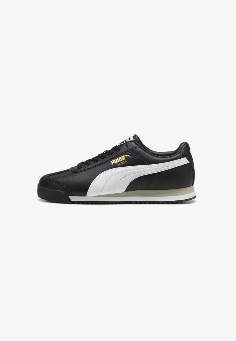 Baskets basses Puma Roma noires avec bande latérale blanche, lacets noirs et logo Puma doré sur le côté. Semelle blanche et beige avec semelle extérieure noire.